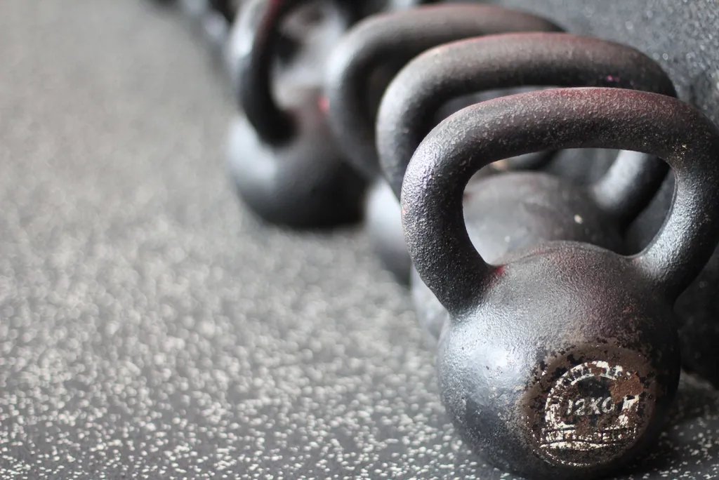 Kettlebells de distintos pesos ordenados en el piso del gimnasio